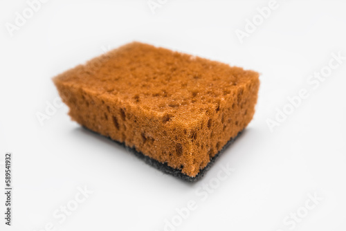 Orange colored used kitchen sponge isolated on white background. Kitchen utensils and domestic chores concept.