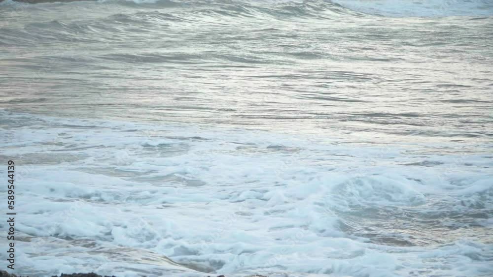 Side view ocean waves rolling on sea shore outdoors in the morning. Closeup foamy water splashing on coast on Cyprus Side view ocean waves rolling on sea shore outdoors in the morning. Closeup foamy water splashing on coast on Cyprus