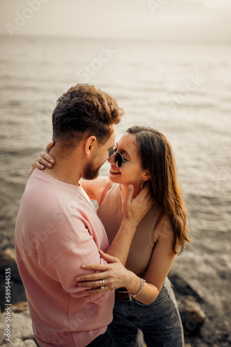 The portrait of young couple in love in romantic honeymoon hugging and kissing each other 