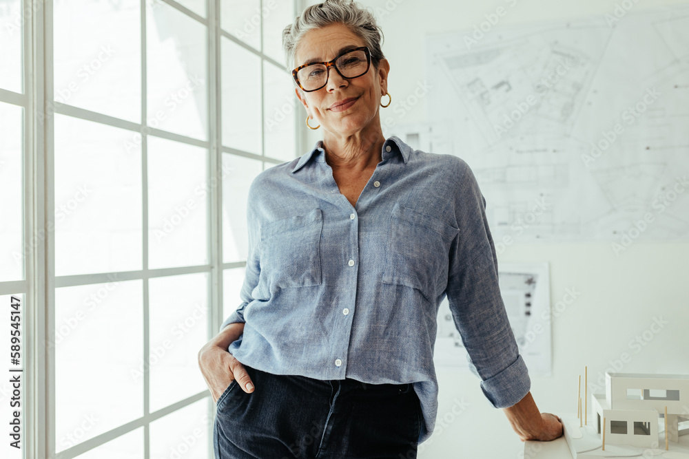 Confident in her creative expertise: Female architect looking at the camera in her office
