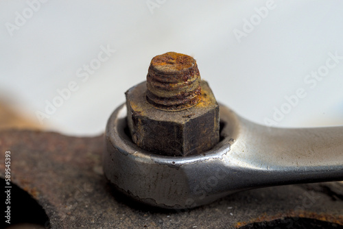 Chrome wrench unscrews the nut close-up