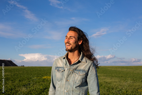Long hair man in green meadow © Milos