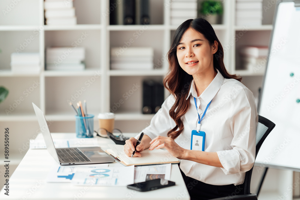 Young Asian Businesswomen smiling and happy used laptop working in the office. Young Asian Businesswomen smiling and happy used laptop working in the office.