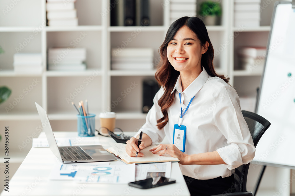 Young Asian Businesswomen smiling and happy used laptop working in the office. Young Asian Businesswomen smiling and happy used laptop working in the office.