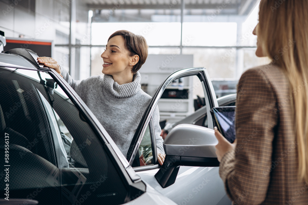 Woman in car showroom talking to salesperson