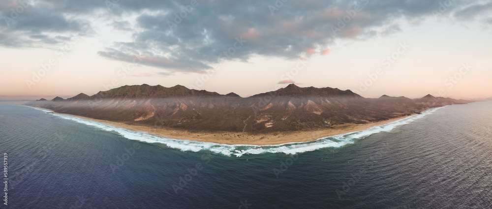 View from above, stunning panoramic view of Cofete beach surrounded by the chain of mountains of the Jandía Natural Park during a beautiful sunset. Fuerteventura, Canary Islands.