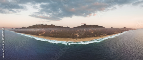 Obraz na płótnie View from above, stunning panoramic view of Cofete beach surrounded by the chain of mountains of the Jandía Natural Park during a beautiful sunset. Fuerteventura, Canary Islands. w salonie