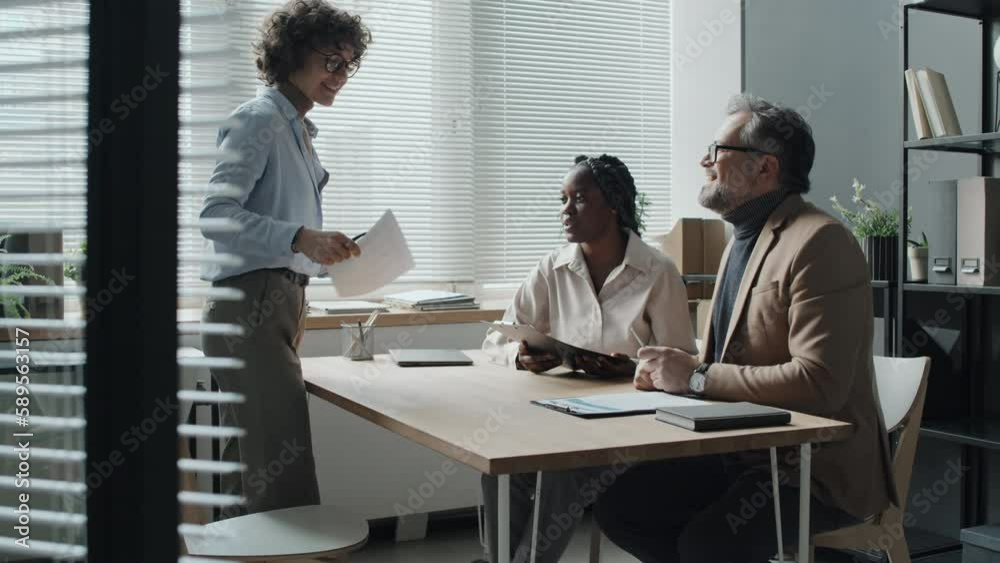 Full medium shot of Caucasian short-haired woman entering office, greeting HRs, black woman and Caucasian spectacled man, presenting her CV, sitting down, shaking hands with both HRs, daytime Full medium shot of Caucasian short-haired woman entering office, greeting HRs, black woman and Caucasian spectacled man, presenting her CV, sitting down, shaking hands with both HRs, daytime