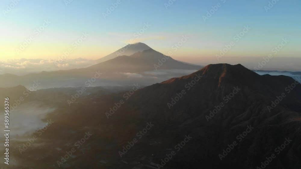 aerial view during sunrise of volcano Mount Batur with Mount Agung in Background aerial view during sunrise of volcano Mount Batur with Mount Agung in Background