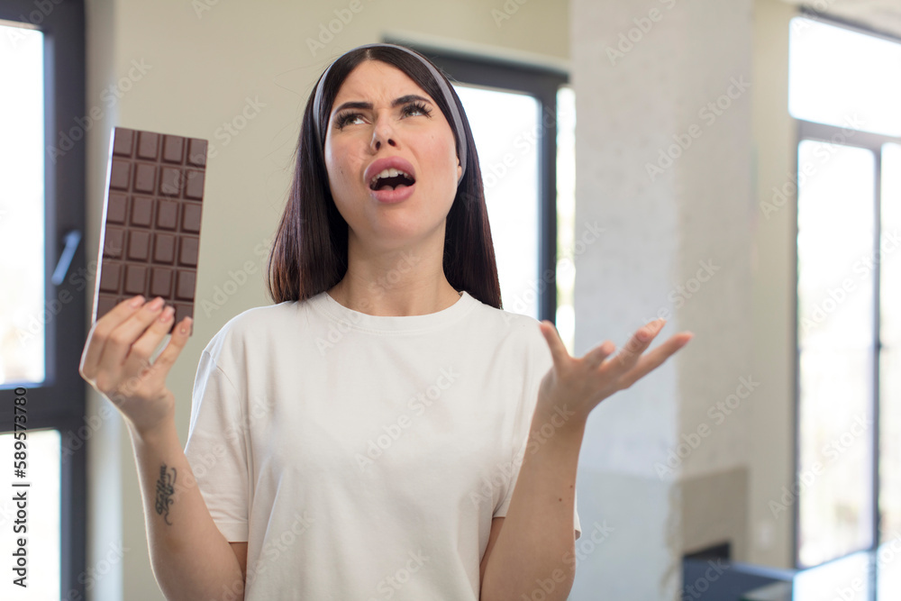 pretty young woman screaming with hands up in the air. chocolate concept pretty young woman screaming with hands up in the air. chocolate concept