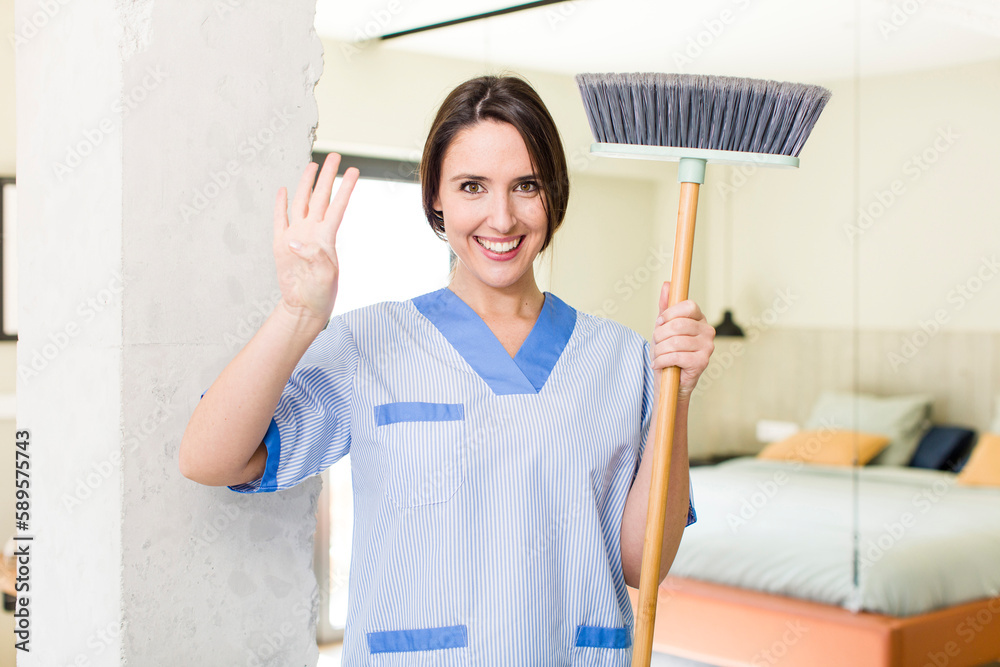 young pretty woman smiling and looking friendly, showing number four. housekeeper concept young pretty woman smiling and looking friendly, showing number four. housekeeper concept
