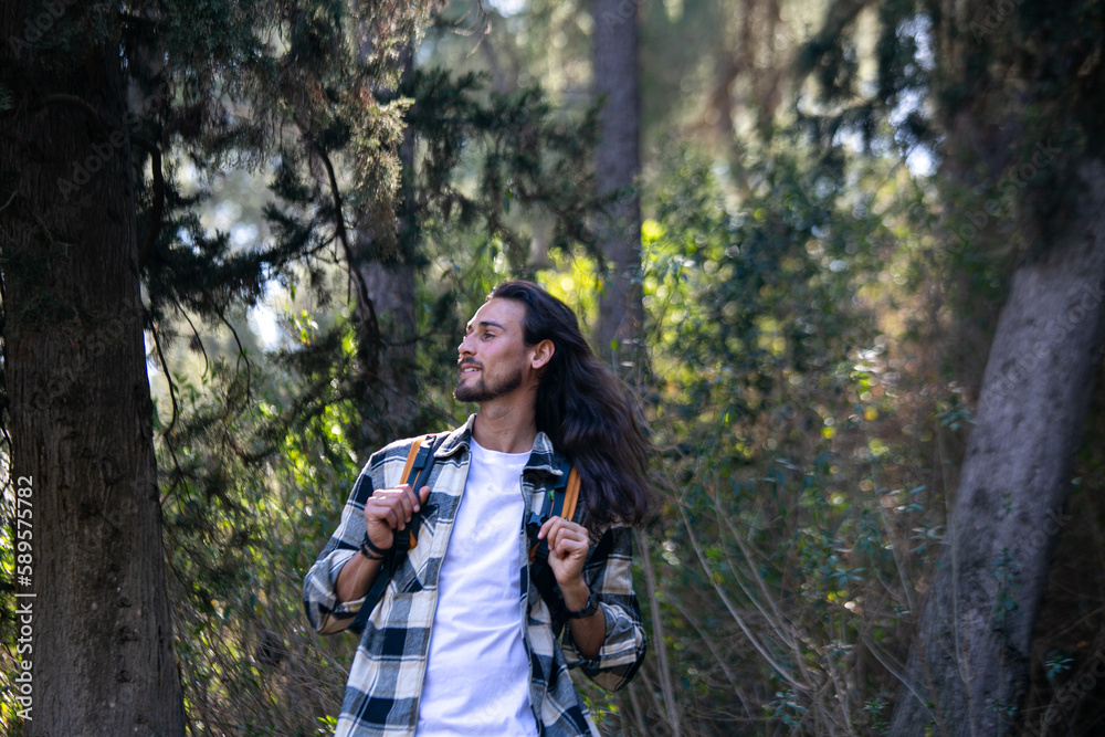 Long hair man in green forest Long hair man in green forest