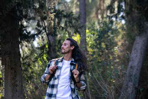 Long hair man in green forest © Milos