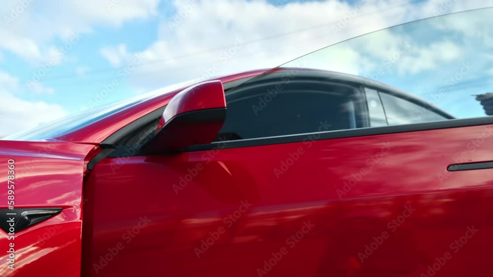 Close view of a woman unlocking her electric red car using a card and getting inside Close view of a woman unlocking her electric red car using a card and getting inside