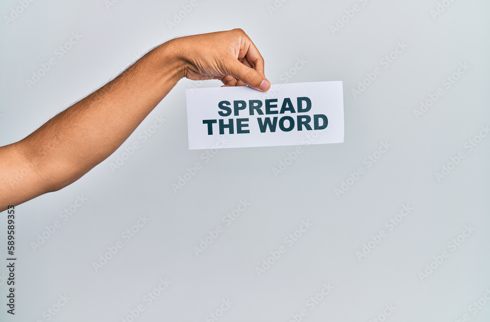 Hand of caucasian man holding paper with spread the word message over isolated white background Hand of caucasian man holding paper with spread the word message over isolated white background