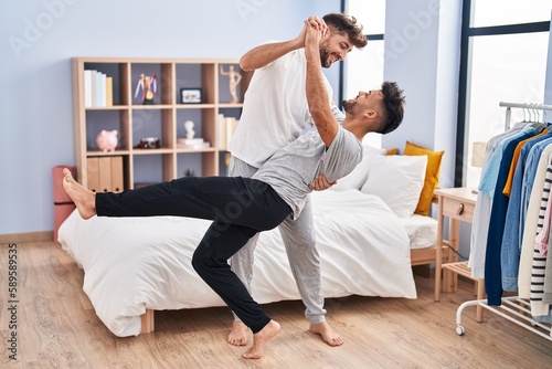 Young couple smiling confident dancing at bedrooom photo