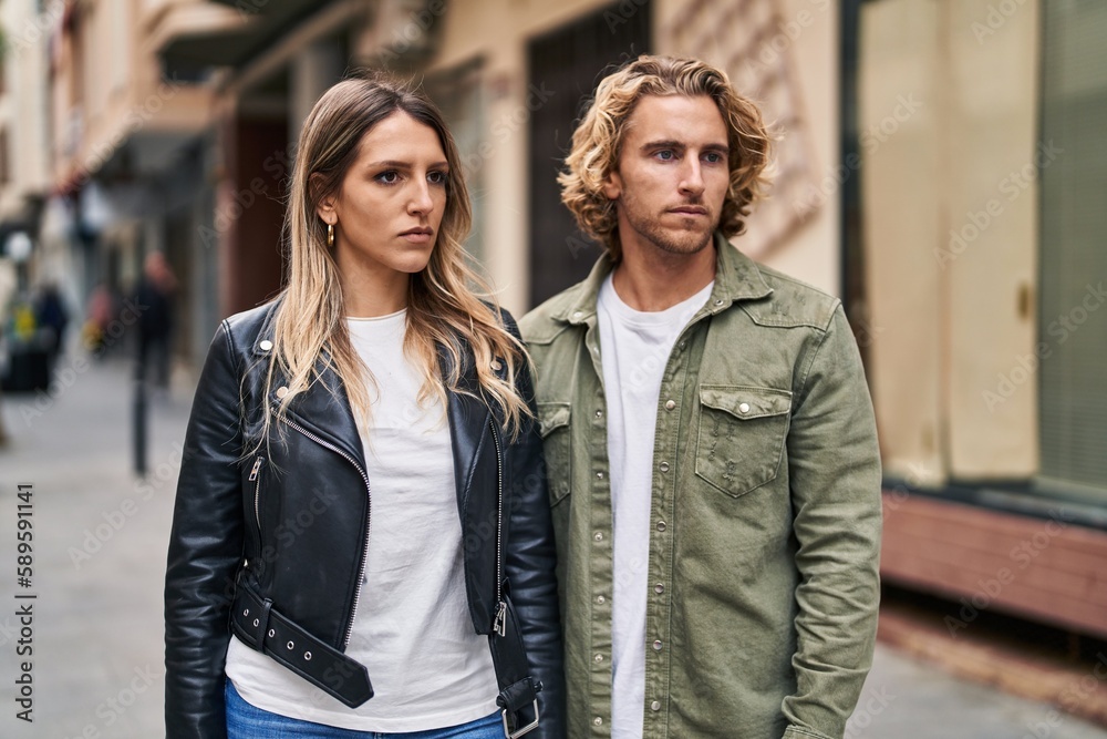 Man and woman couple standing together with relaxed expression at street