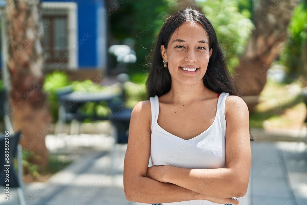 Young beautiful hispanic woman standing with arms crossed gesture at park Young beautiful hispanic woman standing with arms crossed gesture at park