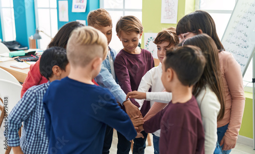 Group of kids students with hands together at classroom