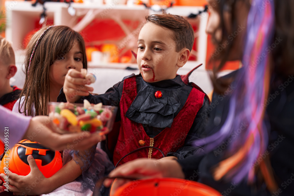 Group of kids wearing halloween costume receiving candies at home