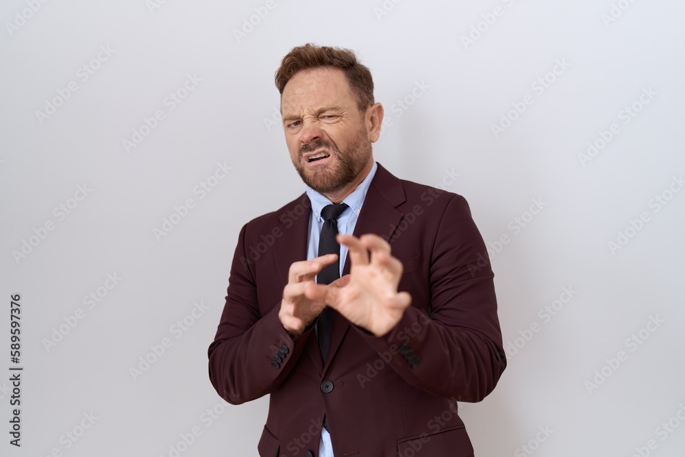 Middle age business man with beard wearing suit and tie disgusted expression, displeased and fearful doing disgust face because aversion reaction. Middle age business man with beard wearing suit and tie disgusted expression, displeased and fearful doing disgust face because aversion reaction.