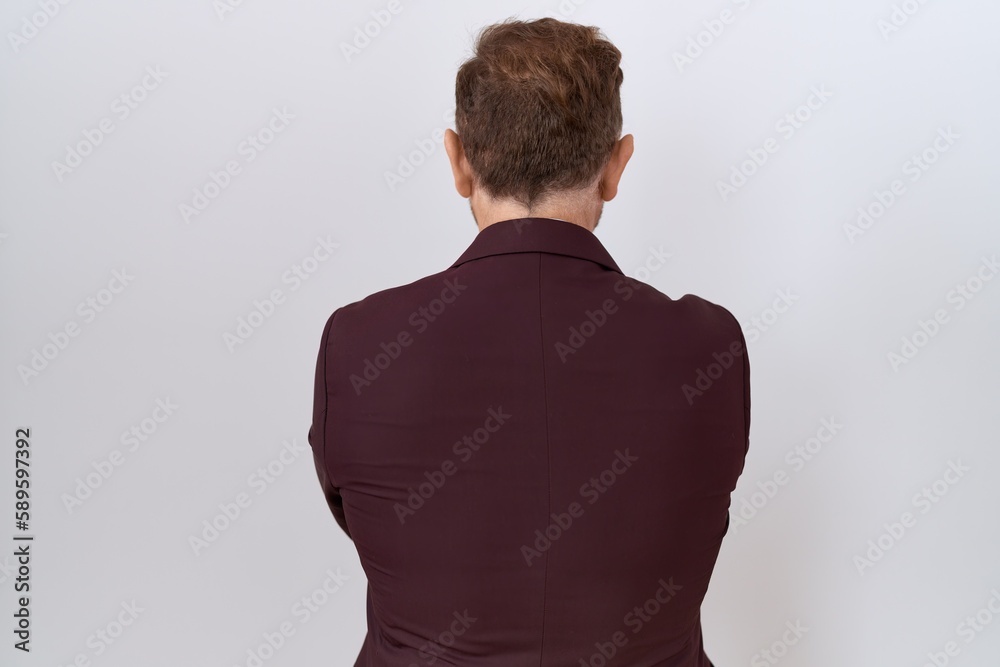 Middle age business man with beard wearing suit and tie standing backwards looking away with crossed arms Middle age business man with beard wearing suit and tie standing backwards looking away with crossed arms