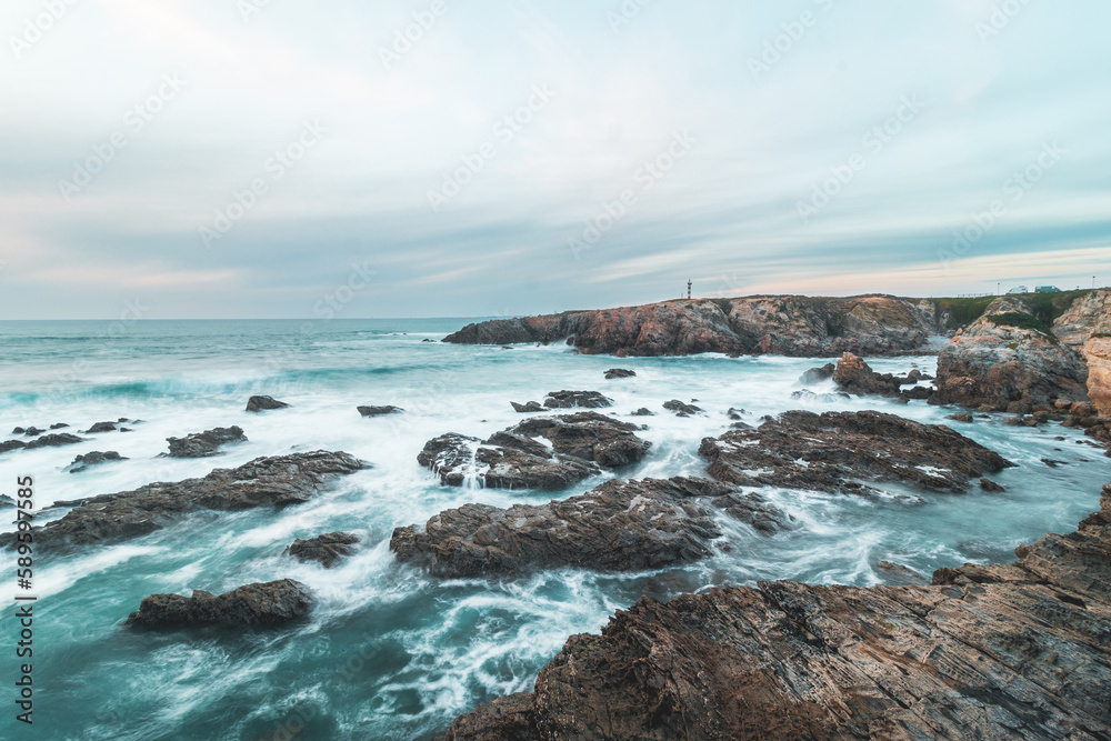 Stormy Atlantic Ocean shows its power with waves crashing into the rocks at sunset off Porto Covo, Portugal. The beauty of the Fisherman Trail, Rota Vicentina