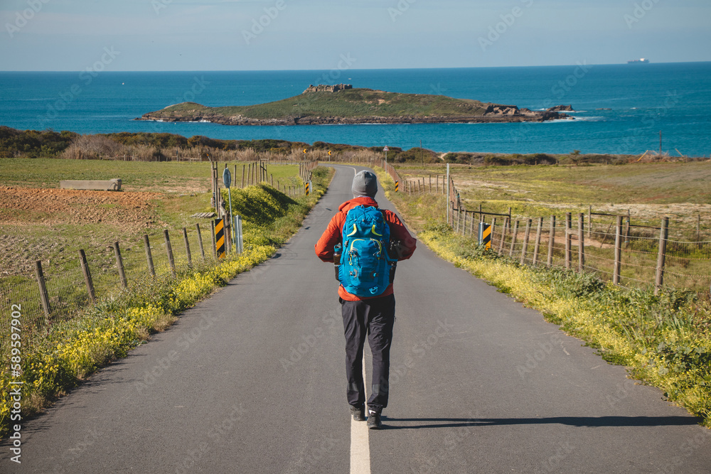 Man full of enthusiasm embarks on his journey along the Fisherman trail - Rota Vicentina along the Atlantic coast of Portugal. Adventurous backpacker hits the road in the spring months