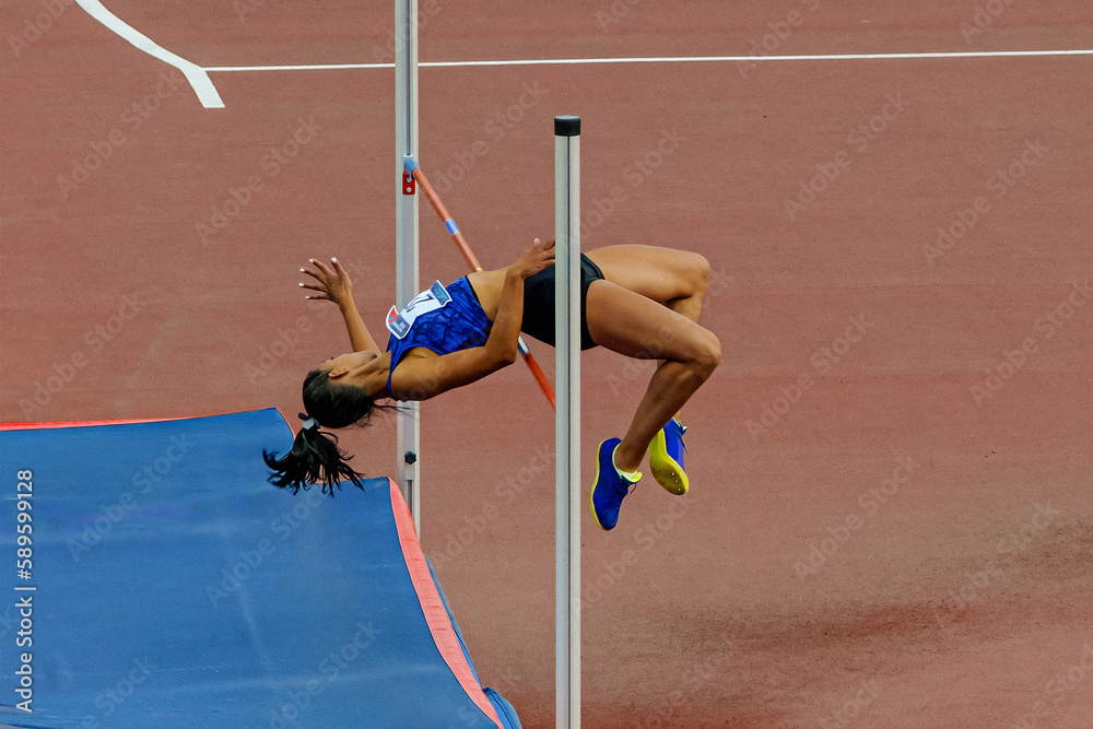 female athlete high jump side view in summer athletics championships