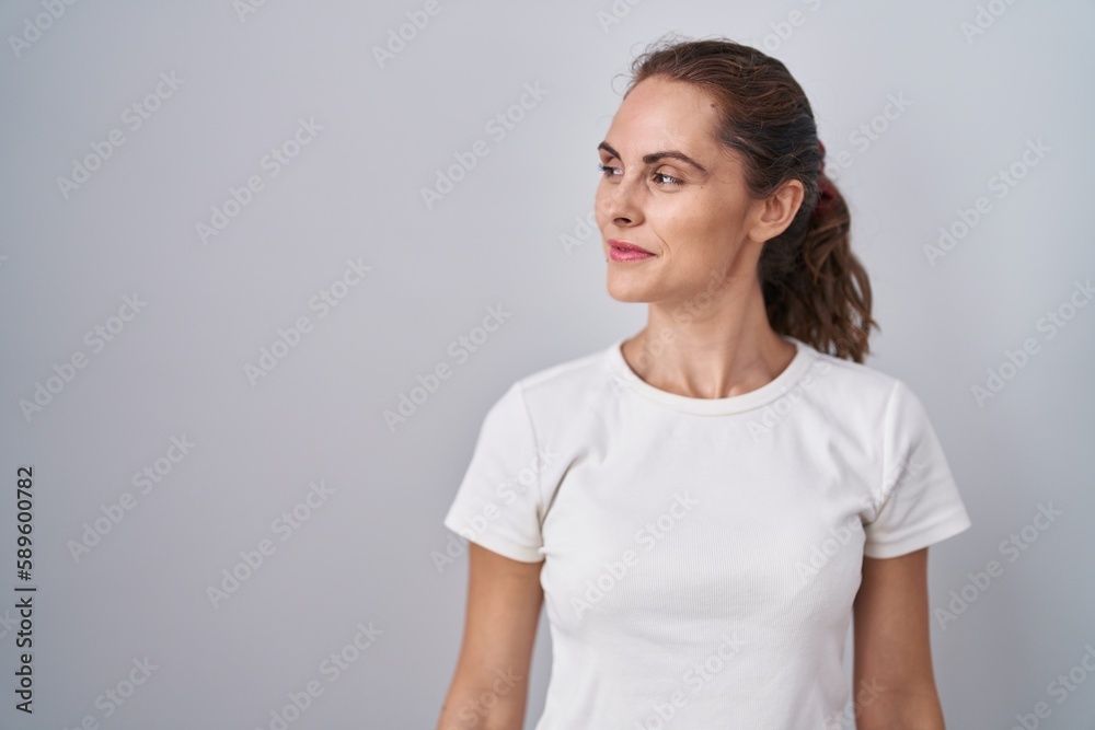 Beautiful brunette woman standing over isolated background smiling looking to the side and staring away thinking. Beautiful brunette woman standing over isolated background smiling looking to the side and staring away thinking.