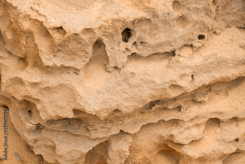 Abstract background of sandy rocks with holes close-up. The concept of soil erosion