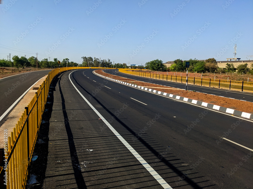 the indian highway road with no vehicles on it with a slight curve