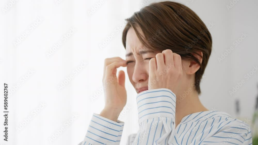 目を掻く若い女性　花粉症イメージ