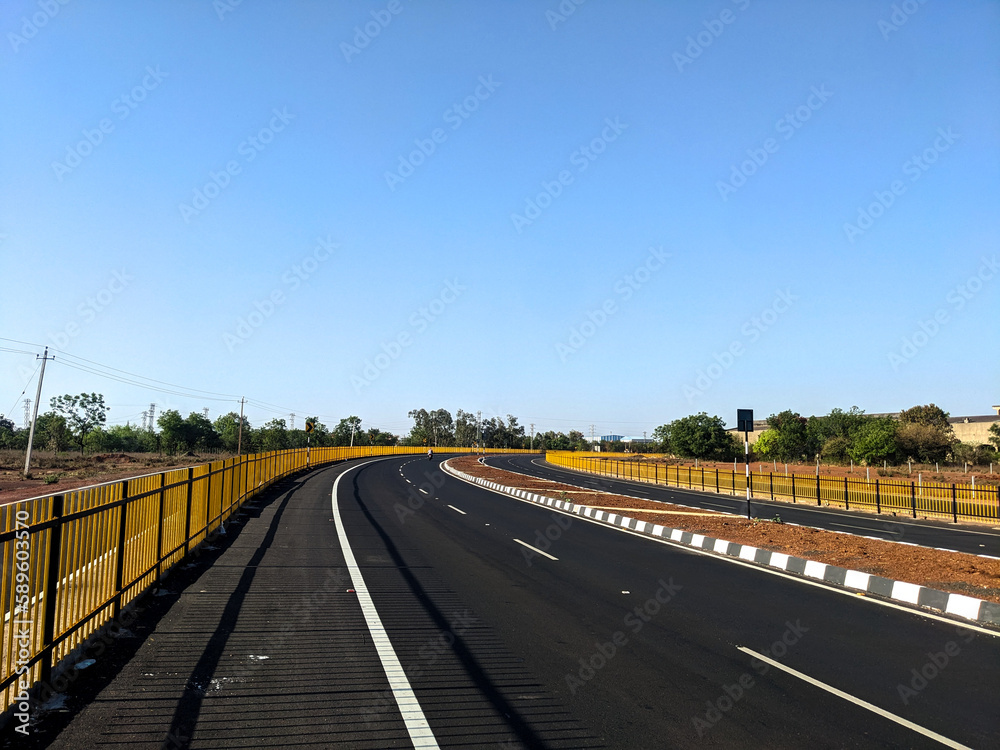 Naklejka premium the indian highway road with slight curve and blue sky