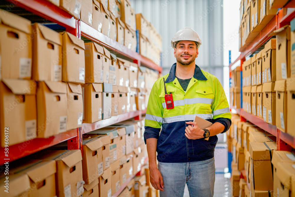 Portrait of professional warehouse worker stand with holding tablet and look at camera in workplace area between shelves with cardbox of product. Portrait of professional warehouse worker stand with holding tablet and look at camera in workplace area between shelves with cardbox of product.