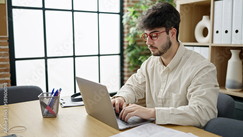 Young hispanic man business worker using laptop working at office