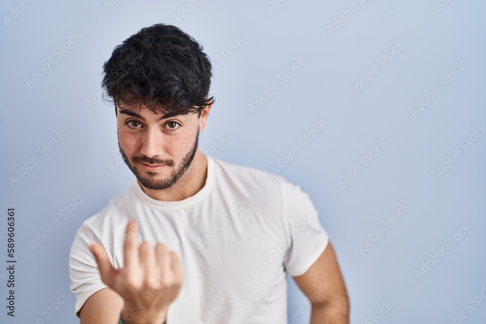 Hispanic man with beard standing over white background beckoning come here gesture with hand inviting welcoming happy and smiling Hispanic man with beard standing over white background beckoning come here gesture with hand inviting welcoming happy and smiling