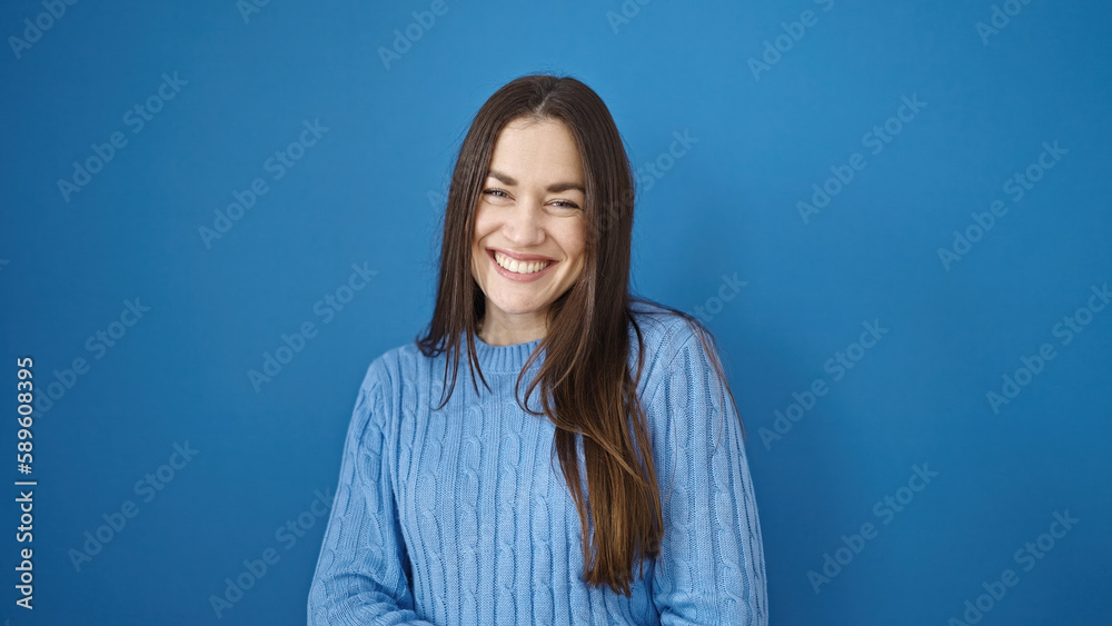 Young caucasian woman smiling confident standing over isolated blue background Young caucasian woman smiling confident standing over isolated blue background