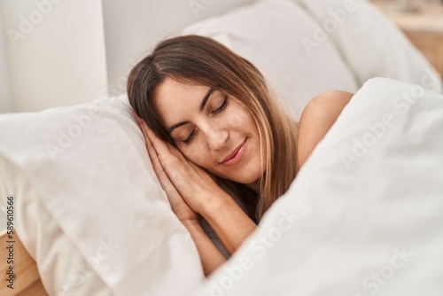 Young woman lying on bed sleeping at bedroom