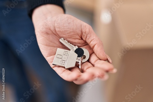 Young woman holding key standing at new home