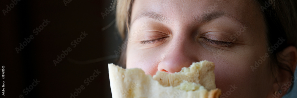 Young woman closing eyes in pleasure and eating tasty shawarma Young woman closing eyes in pleasure and eating tasty shawarma