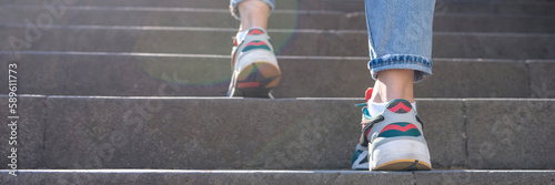 Fototapete Female tourist in casual clothes going upstairs outdoors