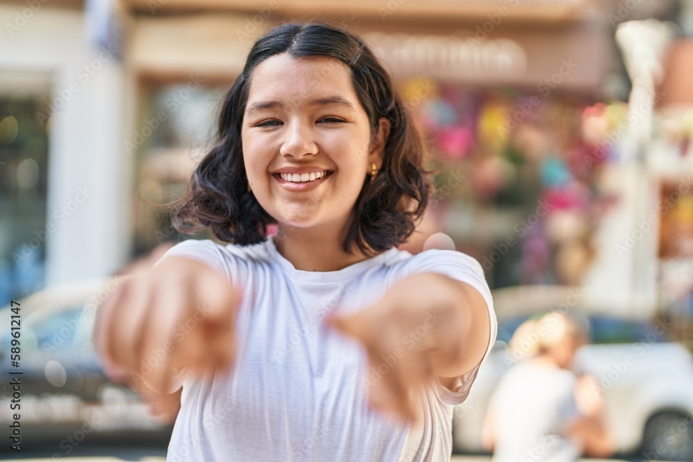 Young woman smiling confident pointing with fingers at street