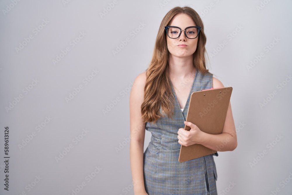 Caucasian woman wearing glasses and business clothes puffing cheeks with funny face. mouth inflated with air, crazy expression.