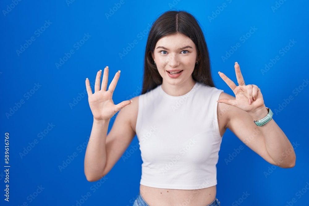 Young caucasian woman standing over blue background showing and pointing up with fingers number eight while smiling confident and happy. Young caucasian woman standing over blue background showing and pointing up with fingers number eight while smiling confident and happy.