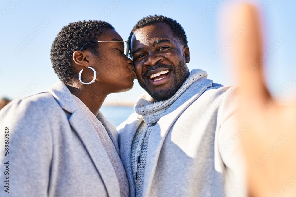 Man and woman couple standing together make selfie by the camera at seaside Man and woman couple standing together make selfie by the camera at seaside