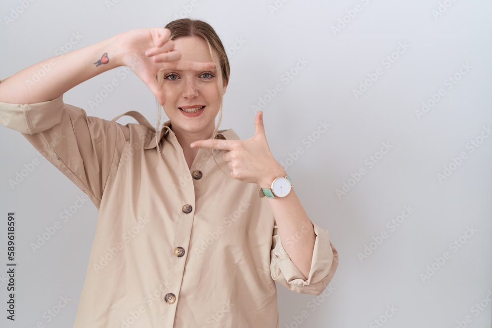 Young caucasian woman wearing casual shirt smiling making frame with hands and fingers with happy face. creativity and photography concept. Young caucasian woman wearing casual shirt smiling making frame with hands and fingers with happy face. creativity and photography concept.