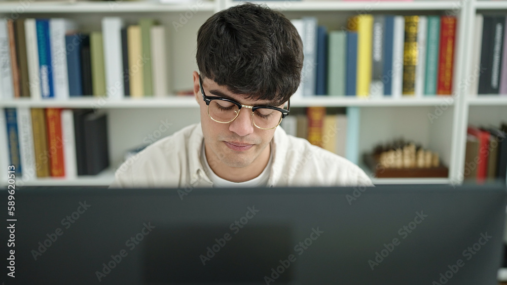 Young hispanic man student using computer studying at library university Young hispanic man student using computer studying at library university