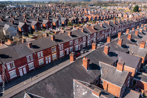 Aerial view above rows of back to back terraced houses on a large council estate