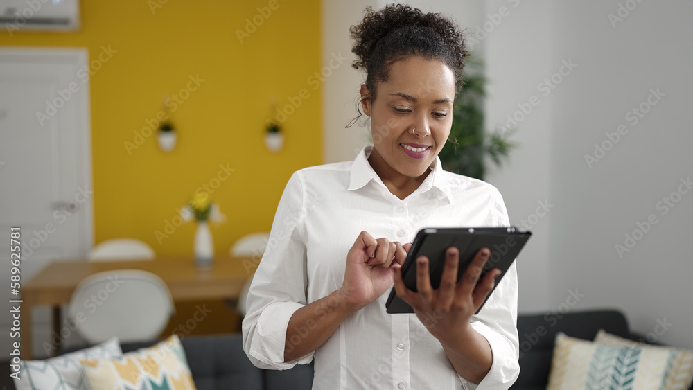 African american woman smiling confident using touchpad at home African american woman smiling confident using touchpad at home
